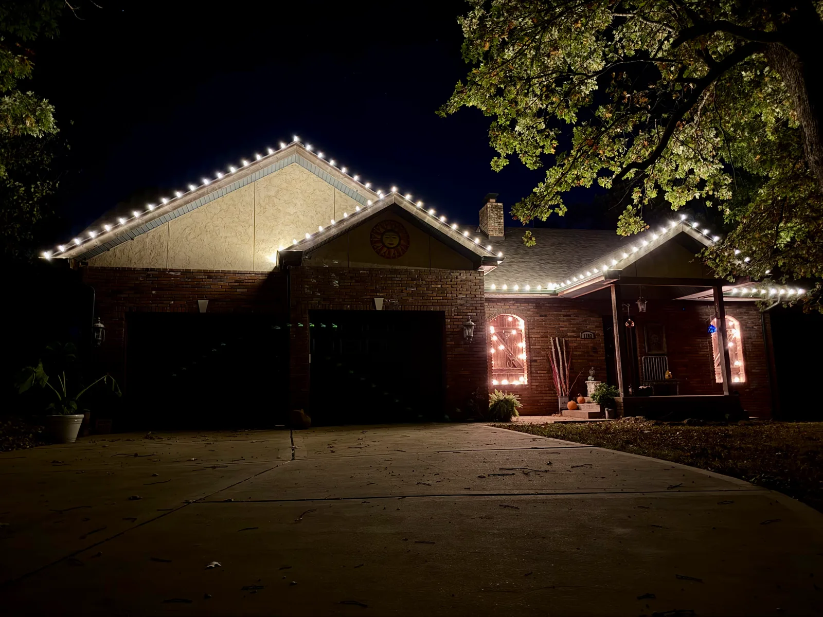 Warm-white C9 roofline lighting on a brick-and-stucco ranch home in the St. Louis area