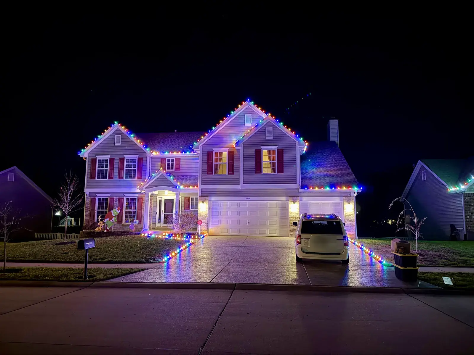 Multicolor C9 roofline and pathway lighting on a two-story St. Louis home