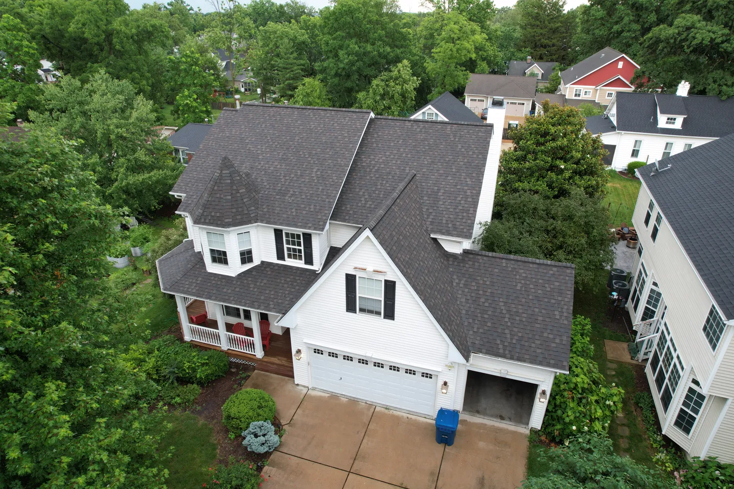 New architectural-shingle roof on a white Victorian home with a turret in the St. Louis area
