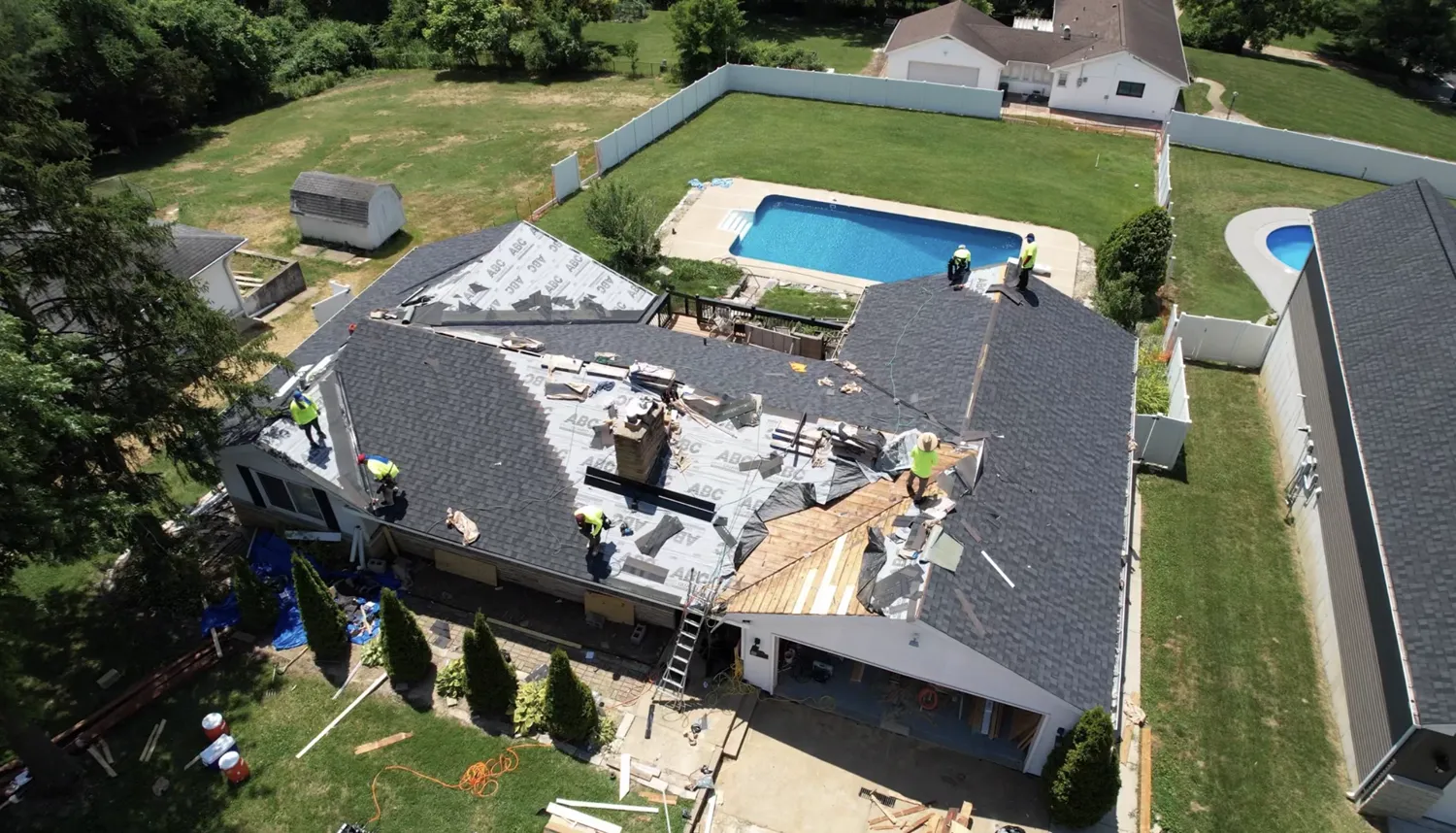 Loxley crew replacing a roof on a home with an in-ground pool