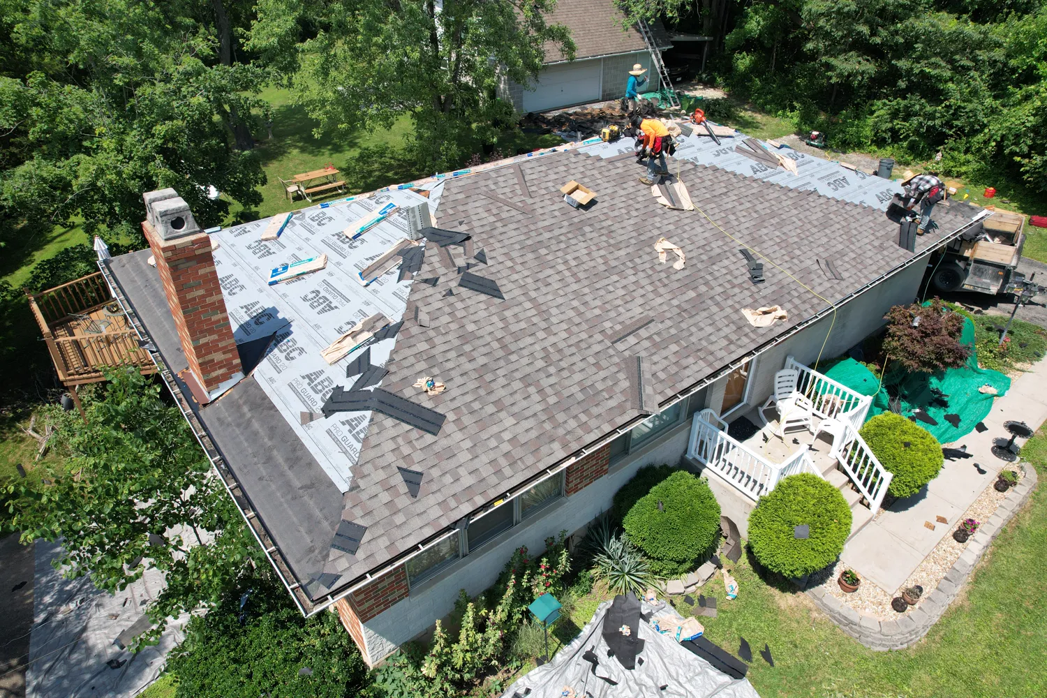 A Loxley roofer on the roof during a replacement, with tarps protecting the yard below