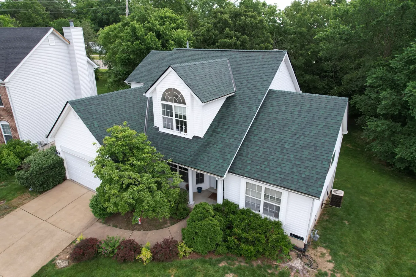 Aerial view of a two-story home with a new green architectural shingle roof